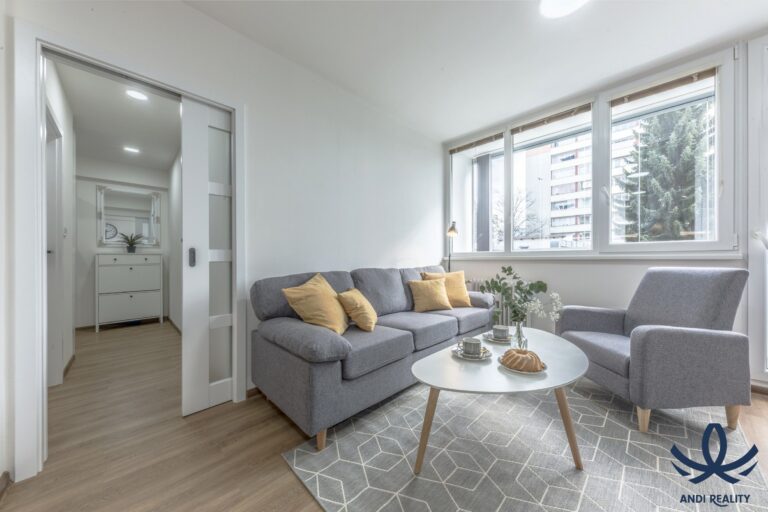 Světlý moderní obývací pokoj s rohovou sedačkou, velkými okny a jídelním koutem.